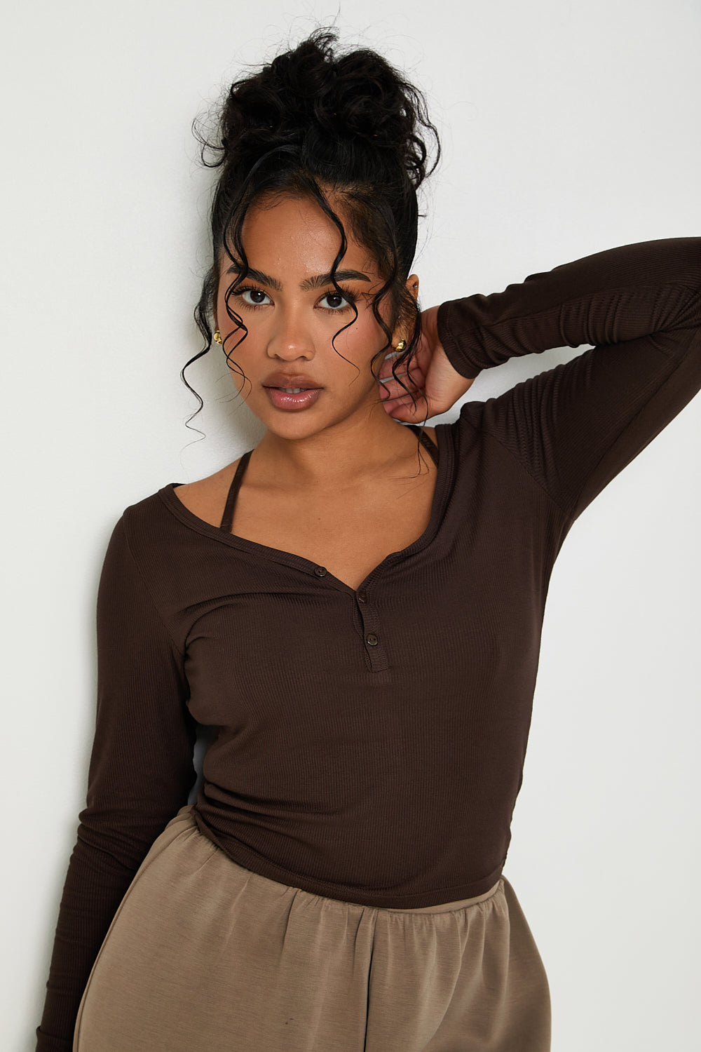 Enhance your wardrobe with our essential Long Sleeve Ribbed Top in Chocolate. This top is made from a premium blend of modal and elastane, providing both softness and stretch for optimal comfort. The sophisticated ribbed texture adds a touch of elegance, while the design allows for a full range of motion. Perfect for layering or wearing alone, our top also features subtle tonal rubber Sundé branding.