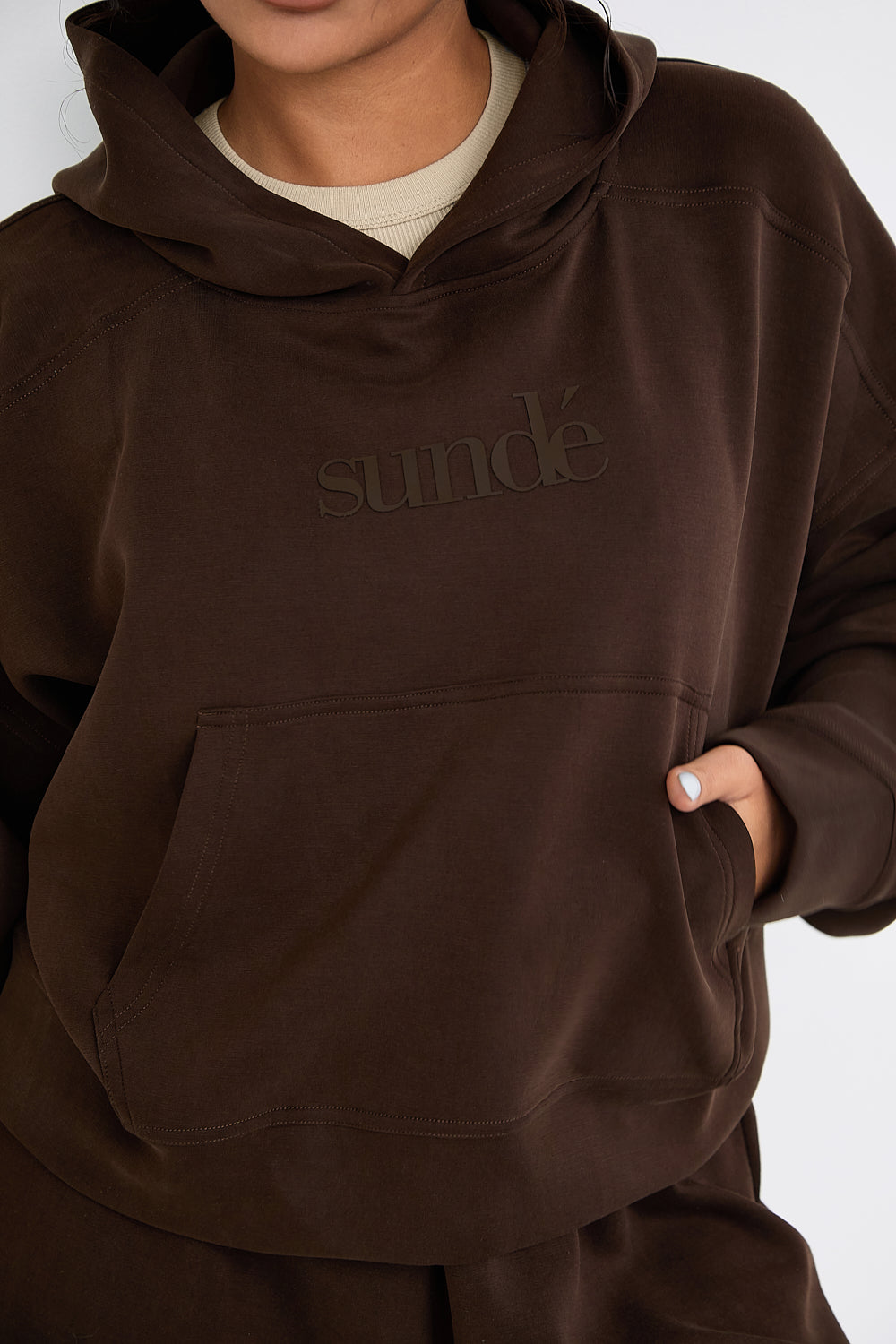 Stay cozy and stylish with our Boxy Cropped Hoodie in rich Chocolate. Made from soft modal, it's perfect for lazy days, paired with matching lounge shorts. Our signature tonal rubber print adds a subtle and sophisticated touch. Upgrade your loungewear collection today.