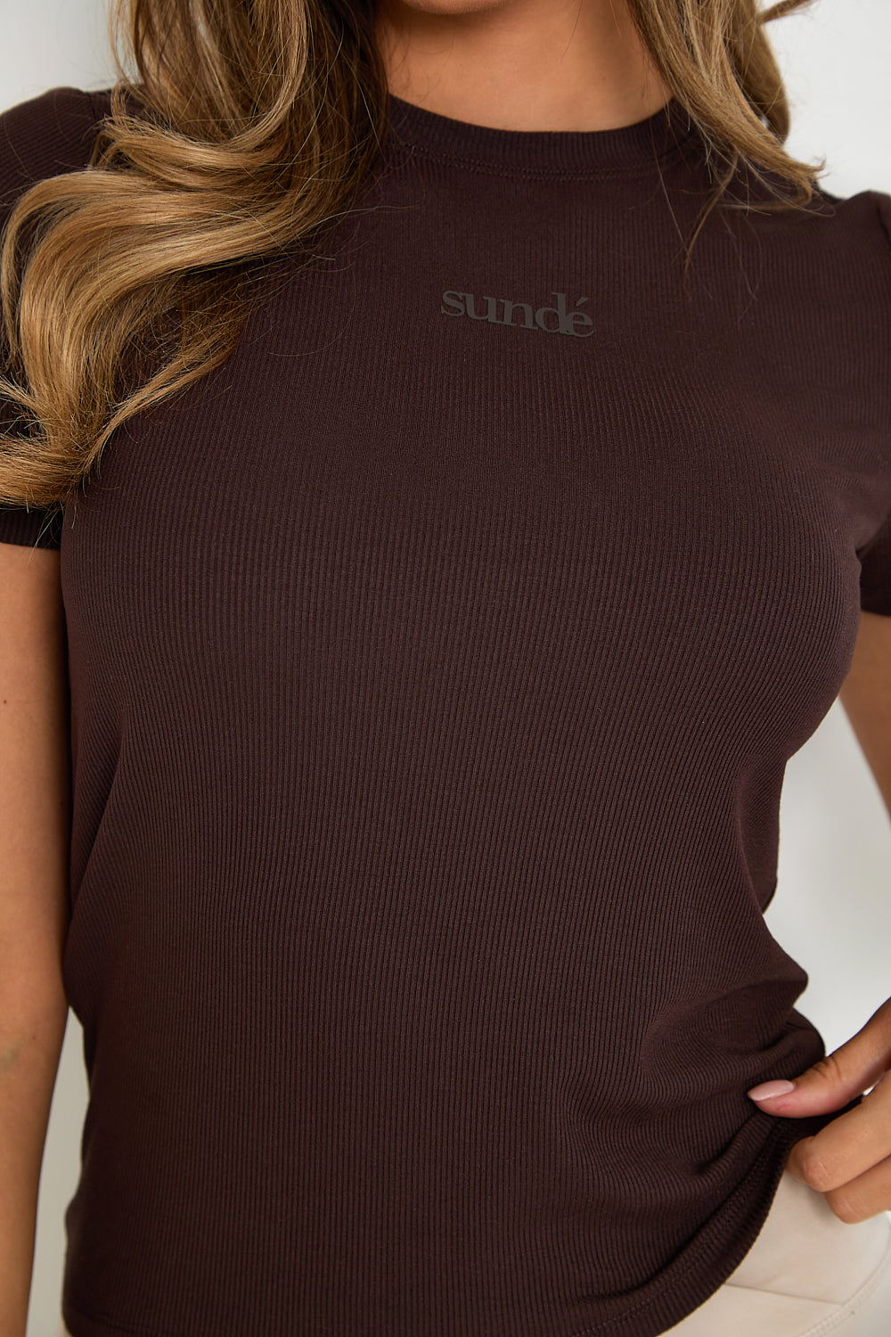 Enjoy an elevated experience with our Ribbed T-Shirt in rich chocolate, expertly crafted from a high-quality blend of modal and elastane. This luxurious and stretchy tee boasts a refined ribbed texture and a chic racerback design for full flexibility and comfort. Perfect for layering or wearing solo, the tee is adorned with subtle tonal rubber Sundé branding for a touch of sophistication. The ideal everyday basic for any wardrobe.