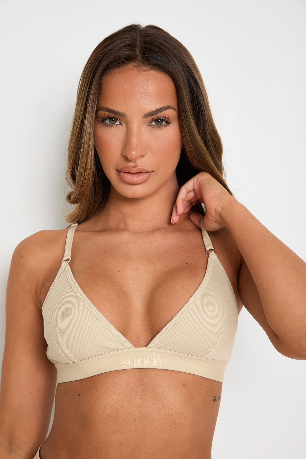 Elevate your style and comfort with our Latte Ribbed Triangle Bralet. Enjoy gentle yet effective support, a triangular neckline, and adjustable 2-way straps for a personalised fit. This seamless bralet boasts a smooth profile under any outfit, thanks to its ribbed design and blend of Lyocell, cotton, and spandex. Perfect for lounging or layering, this essential garment offers both long-lasting comfort and sophisticated appeal, making it a must-have for any fashion-forward wardrobe.