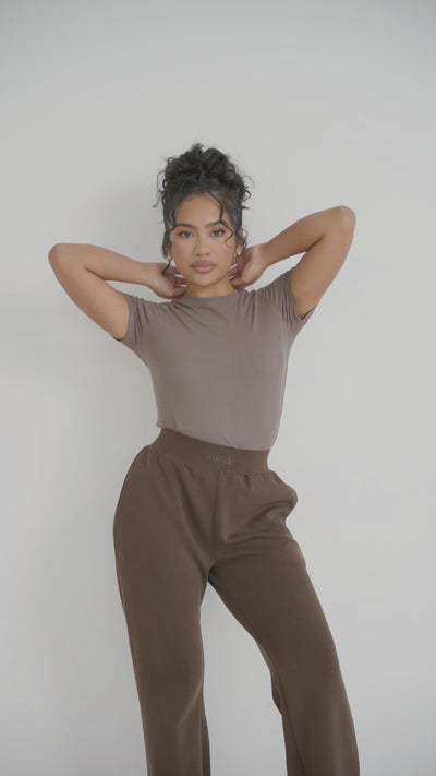 Experience luxury and comfort with our Ribbed T-Shirt in Mocha. Made from modal and elastane, this stretchy tee features a refined ribbed texture and racerback design for flexibility. Perfect for any occasion, it also boasts subtle Sundé branding for a touch of sophistication. Elevate your wardrobe with this everyday essential.